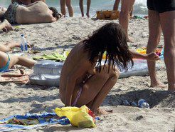 Swarthy babe on the beach takes off her...
