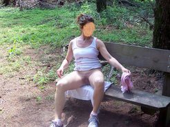 Spreading legs on a bench at park in public