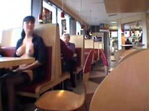 Busty brunette woman topless in the fast food